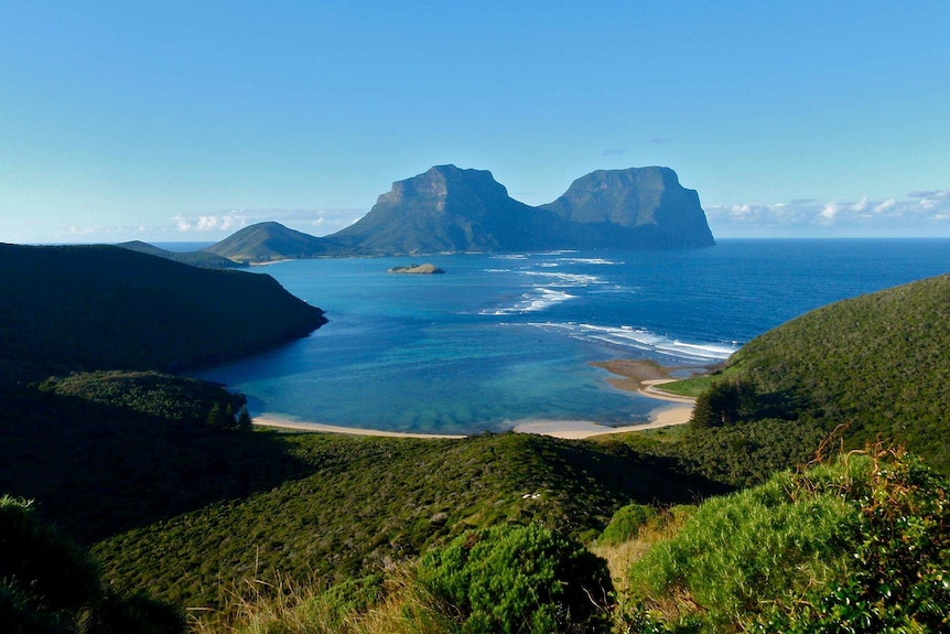 Lord Howe Island with beach in the foreground and rocky outcrops in the background