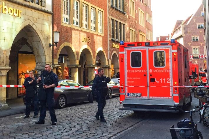 Policemen are seen on the street next to a firefighting truck.