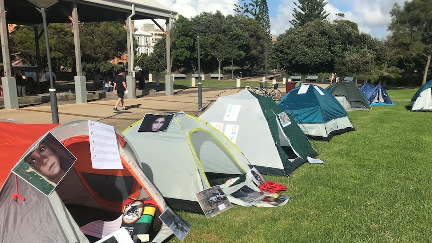 A row of tents at a rally, highlighting homelessness
