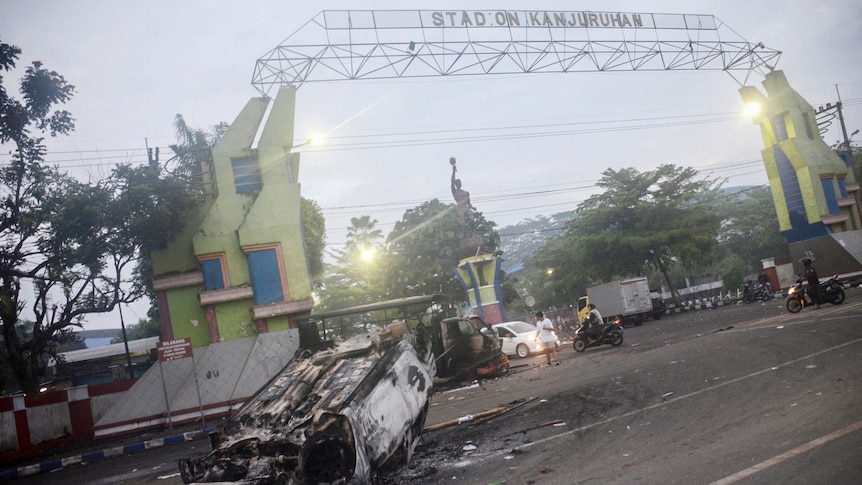A torched car sits outside Kanjuruhan football stadium in Malang.