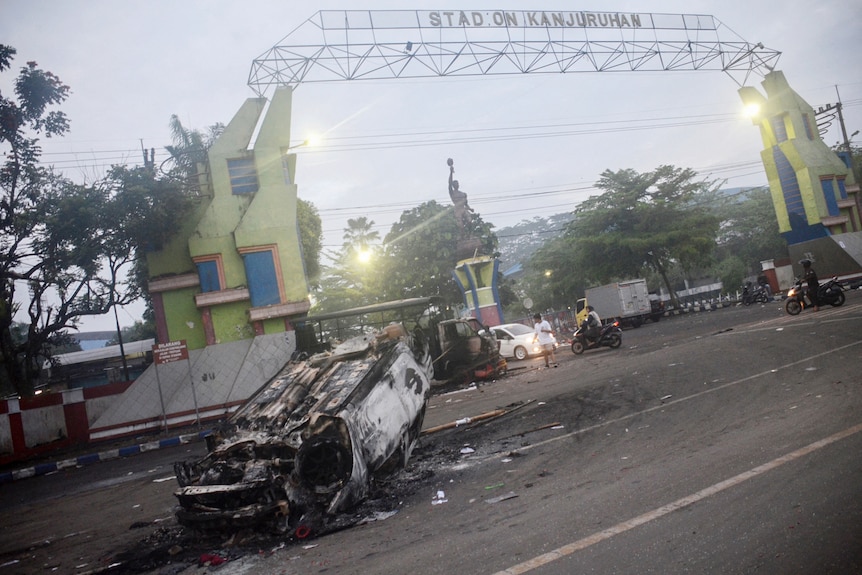 A torched car sits outside Kanjuruhan football stadium in Malang.