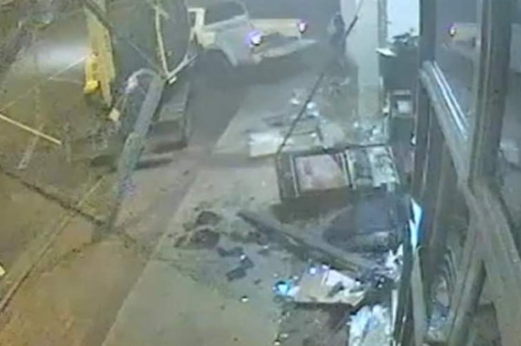 CCTV vision shows an excavator smashing through the front of a bank.