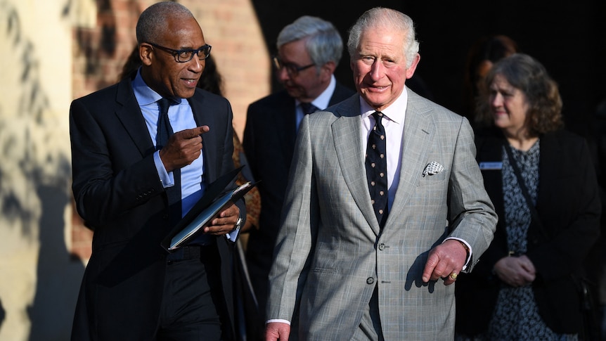 Lord Simon Woolley and King Charles walking together.
