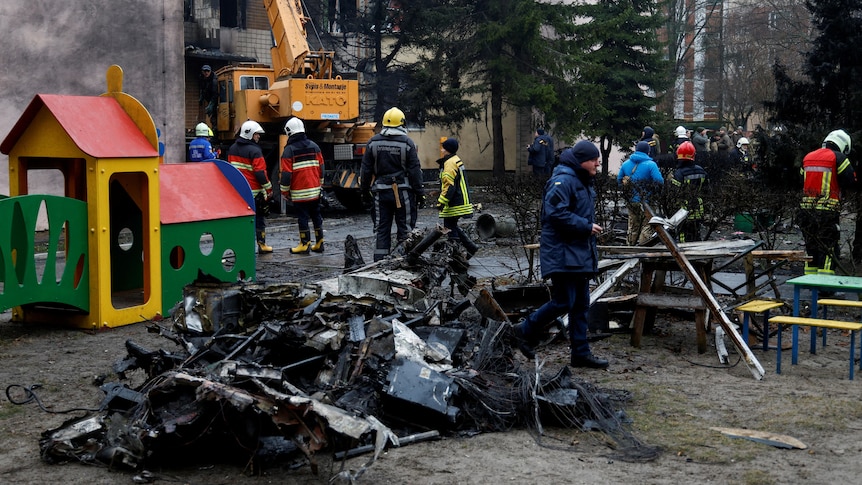 The wreckage of a helicopter lies in a playground in Kyiv.