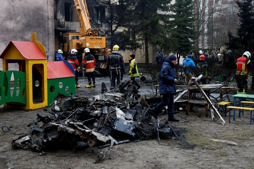 The wreckage of a helicopter lies in a playground in Kyiv.
