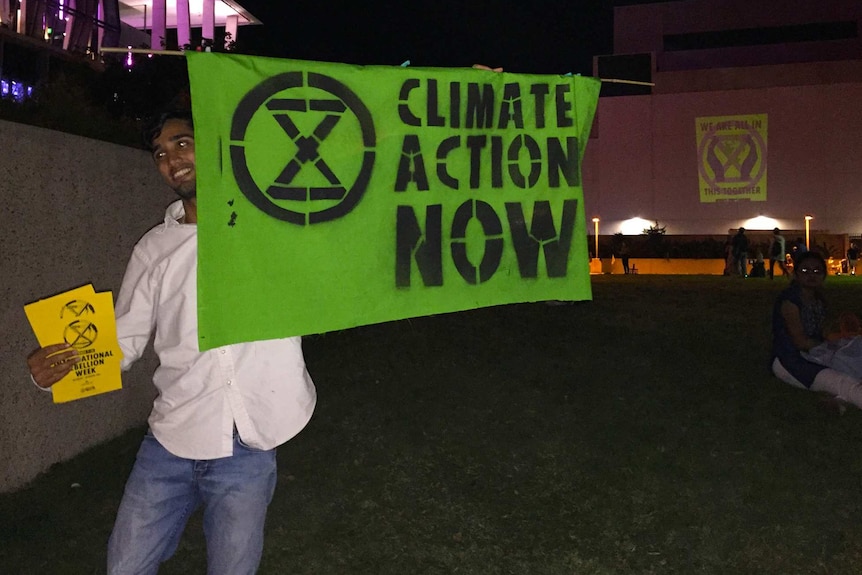 Extinction Rebellion protester with a sign saying "Climate Action Now" near QPAC in Brisbane