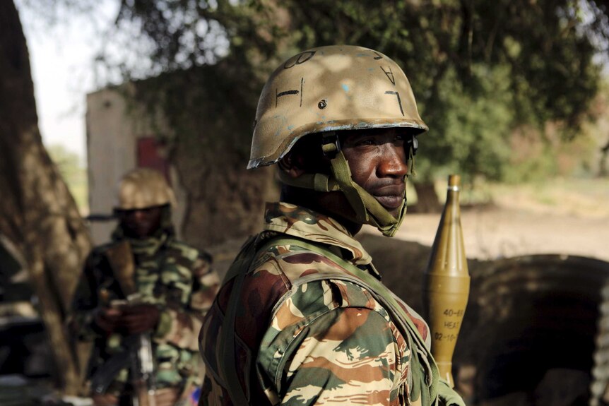 Nigerien soldiers stand guard at the border with Niger