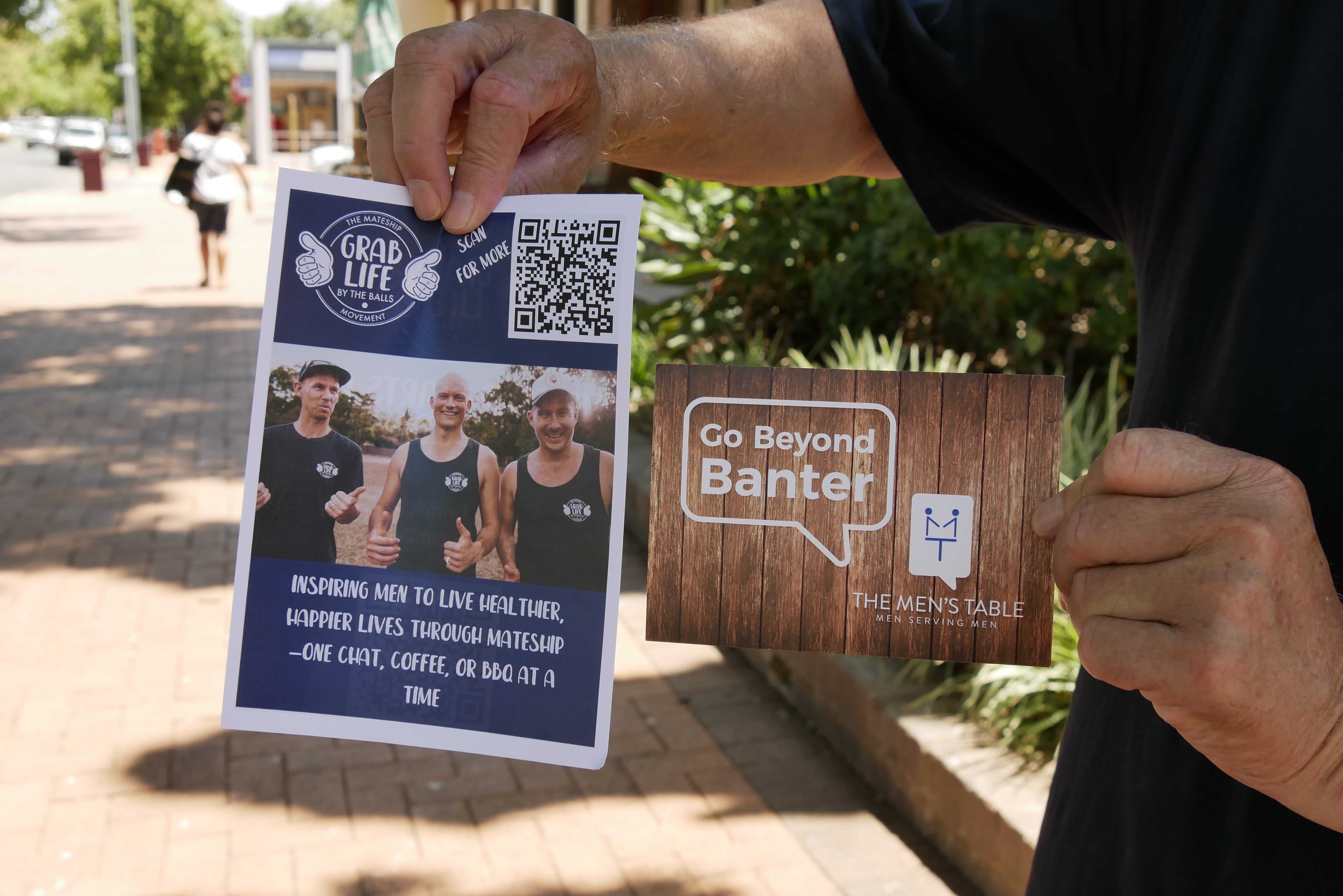 La mano de una persona sostiene dos folletos. 