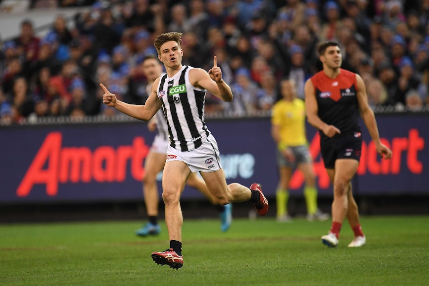 Josh Thomas celebrates a goal for the Magpies against the Demons.
