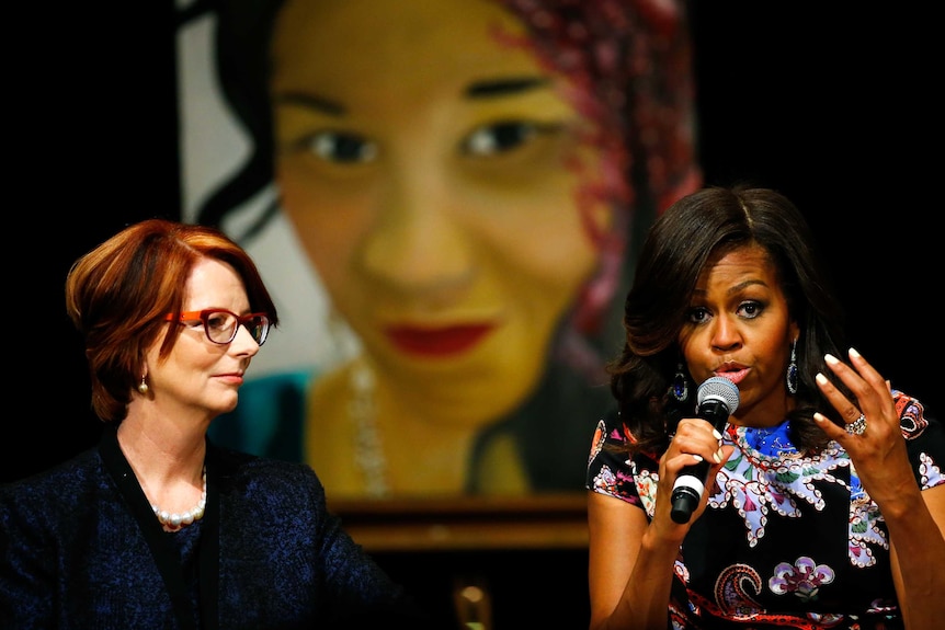 Australia's former Prime Minister Julia Gillard (L) joins U.S. First Lady Michelle Obama as she speaks to pupils during a visit to Mulberry school for girls in London