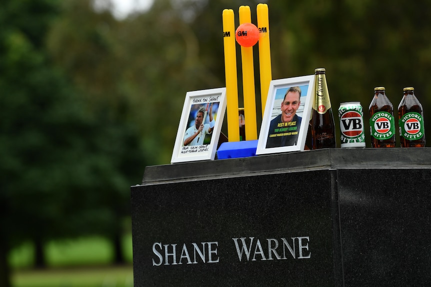 Wickets, pictures and beer sit atop Shane Warne's statue platform at the MCG