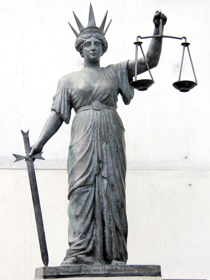 The scales of justice stand outside the Supreme Court building in Brisbane