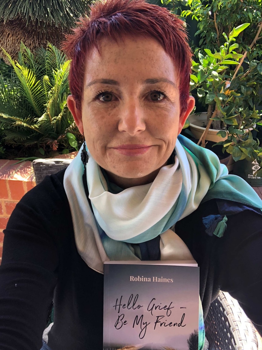 Robina Haines, holding her new book.