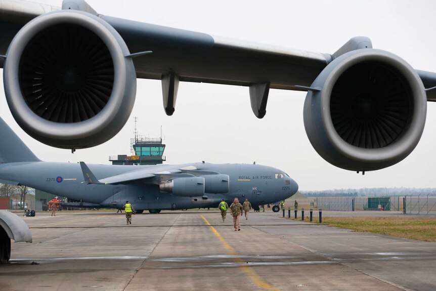 A broken down Royal Air Force C-17 stands in the foreground as another prepares to be loaded with French military equipment.