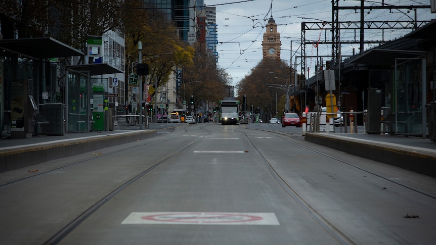 An empty street in Melbourne with a tram in the distance.