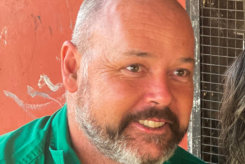 A close up of a man with a beard looking beyond the camera. 