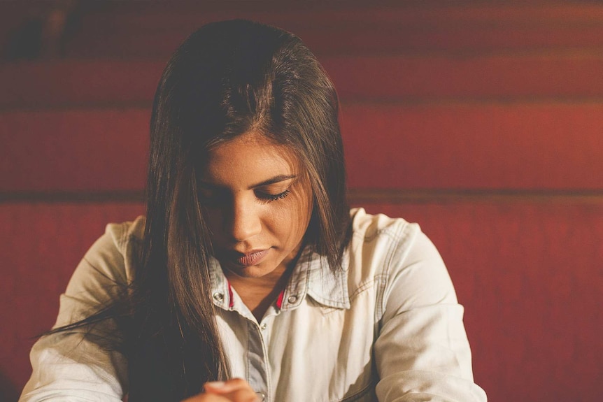 Sad woman who may be praying.