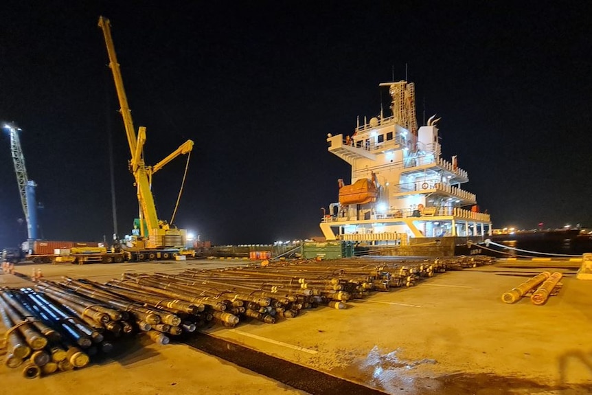 Pipes laid out on the ground at a port