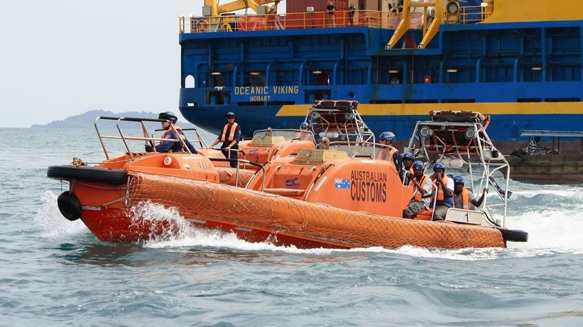 Sri Lankan refugees are transferred by dinghy to Indonesian ferries from the Oceanic Viking