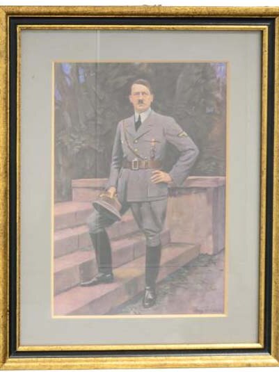 A framed watercolour painting of Adolf Hitler, standing in military uniform with hand on hip and foot on steps.