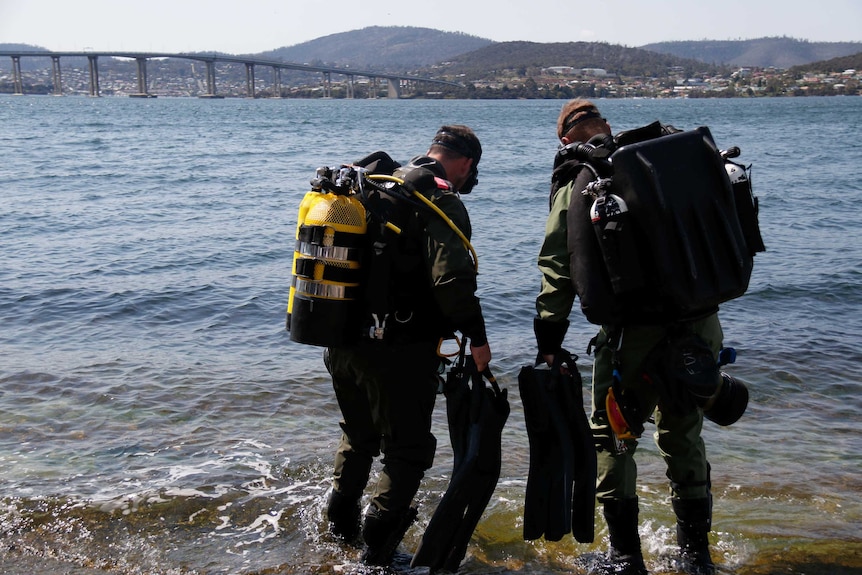 Two British clearance divers enter the Derwent