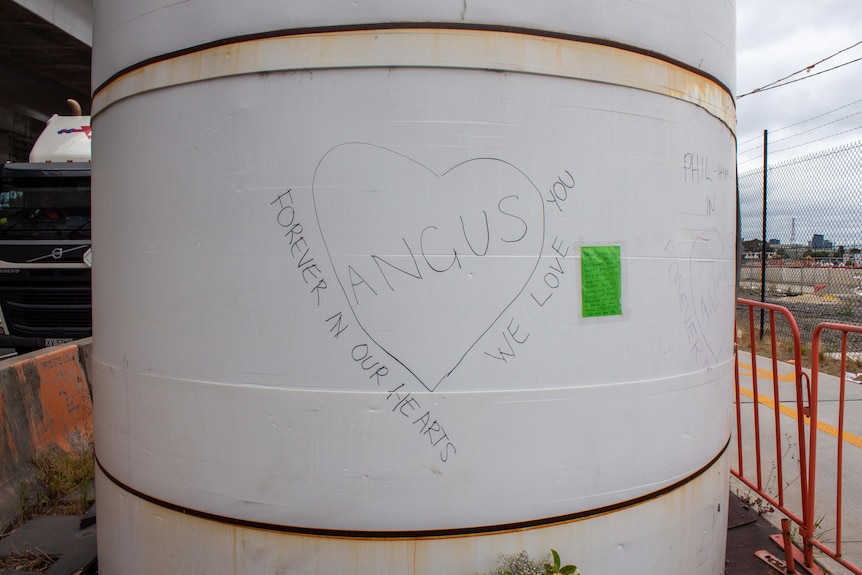 a big concrete pole with a love heart drawn on which says 'Angus, Forever in our hears, we love you'