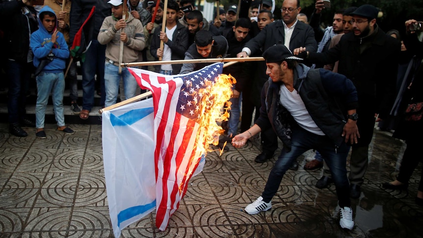 Palestinians burn an Israeli and a US flag