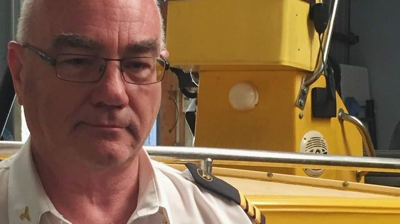 Colin Ritchens, Deputy Commodore West Victoria Squadron stands in the foreground in front of the 30 year old rescue vessel