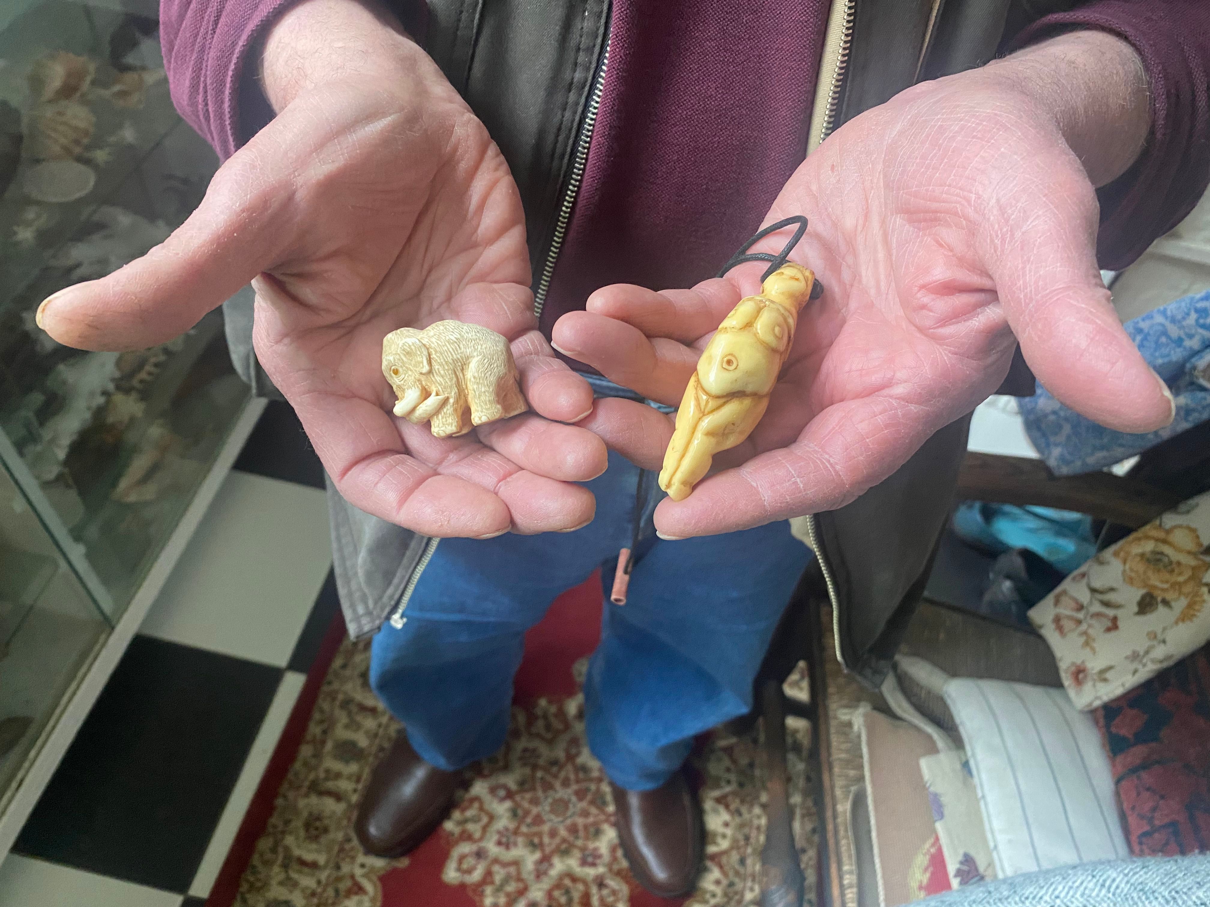 mammoth and Venus figurines in palms of a man's hands