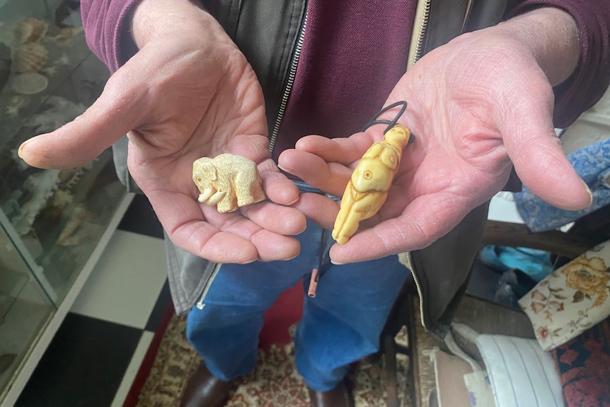 mammoth and Venus figurines in palms of a man's hands