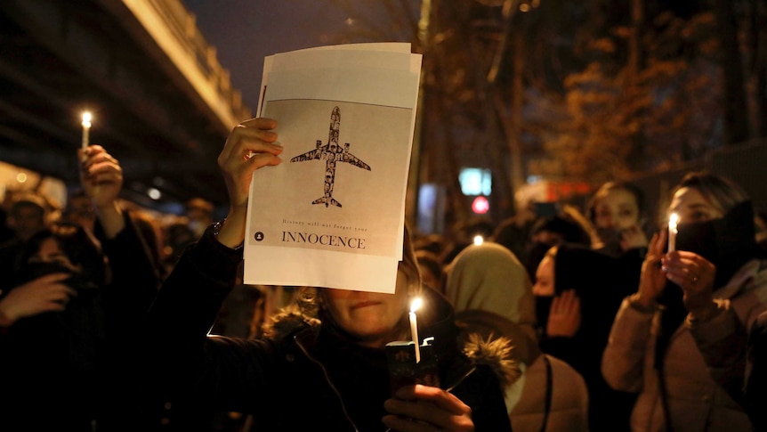 People gather for a candlelight vigil to remember the victims of the Ukraine plane crash.