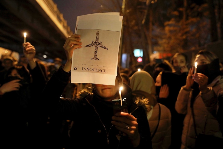 People gather for a candlelight vigil to remember the victims of the Ukraine plane crash.