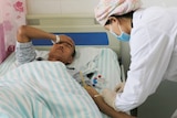A man in a hospital receives treatment from a doctor. 