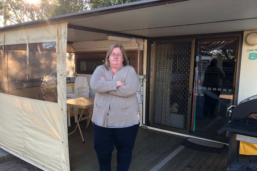 Permanent caravan tenant Linda Shinner stands with her arms crossed in front of her 40-year-old caravan.