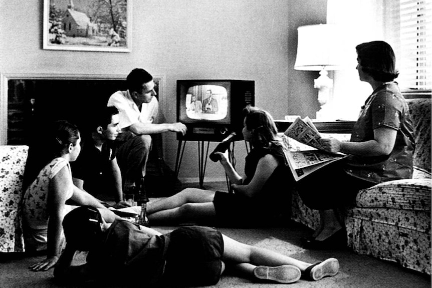 Black and white photo of a family watching television