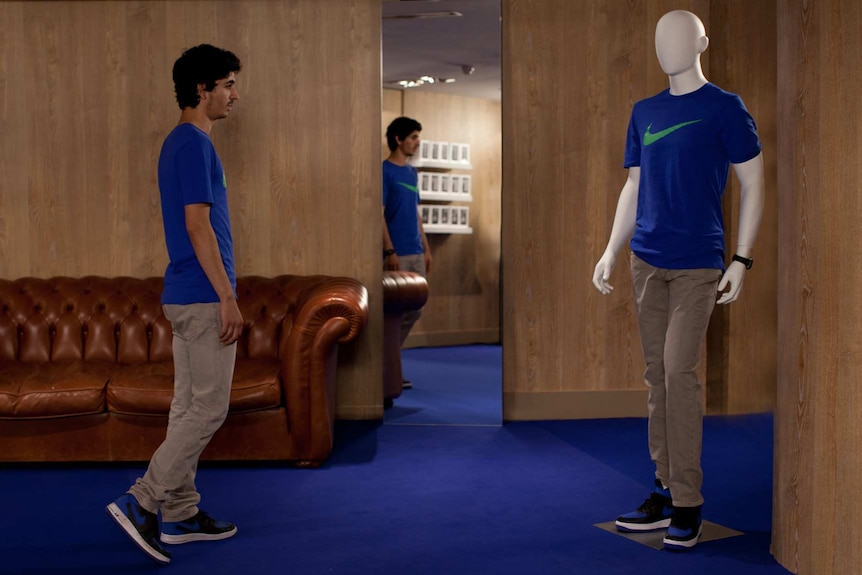 Colour still image of actor Hamza Meziani dressed exactly the same as a store mannequin, in 20176 French film Nocturama.