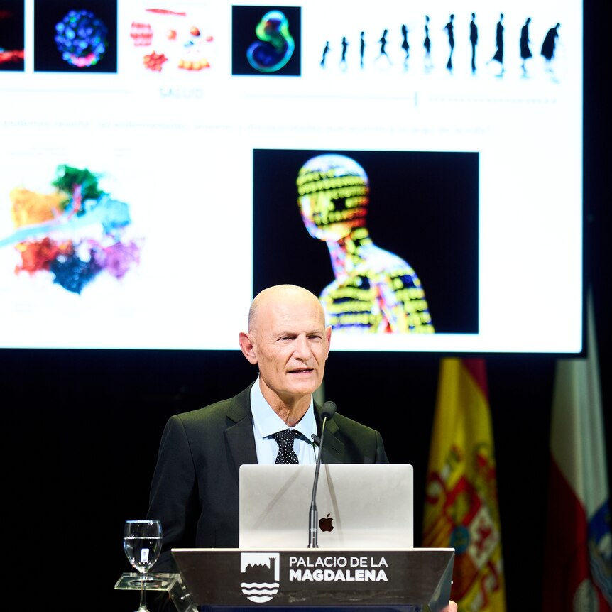 Spanish scientist Juan Carlos Izpisua Belmonte speaking at a conference with projected images behind him