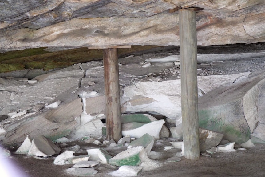 Inside a sandstone cave, the roof held up with timber posts and, the back of the cave has recently fallen, a lot of cracking.