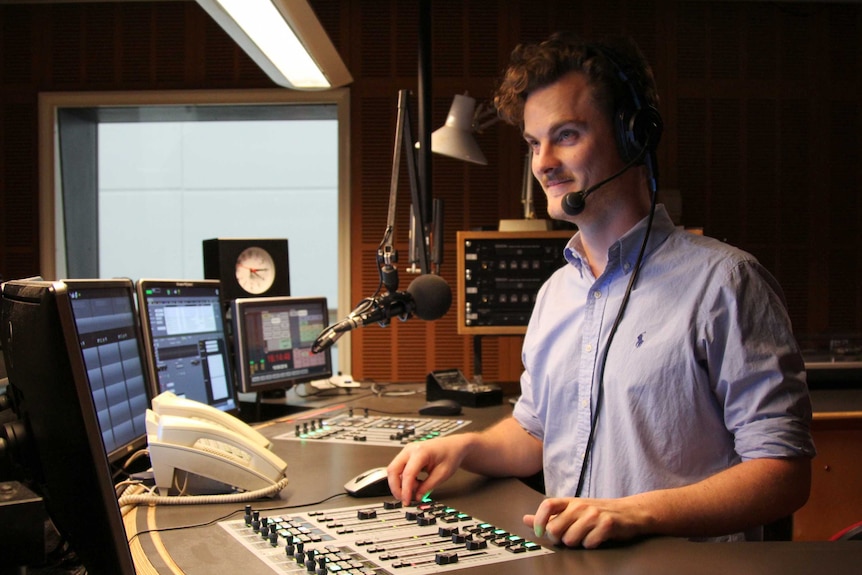Wilson with headset on in radio studio.