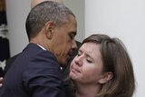 Barack Obama hugs a family member of a Newtown victim after delivering a statement on measures to reduce gun violence.