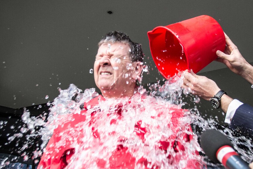 A bucket of ice water is poured over Red Symons