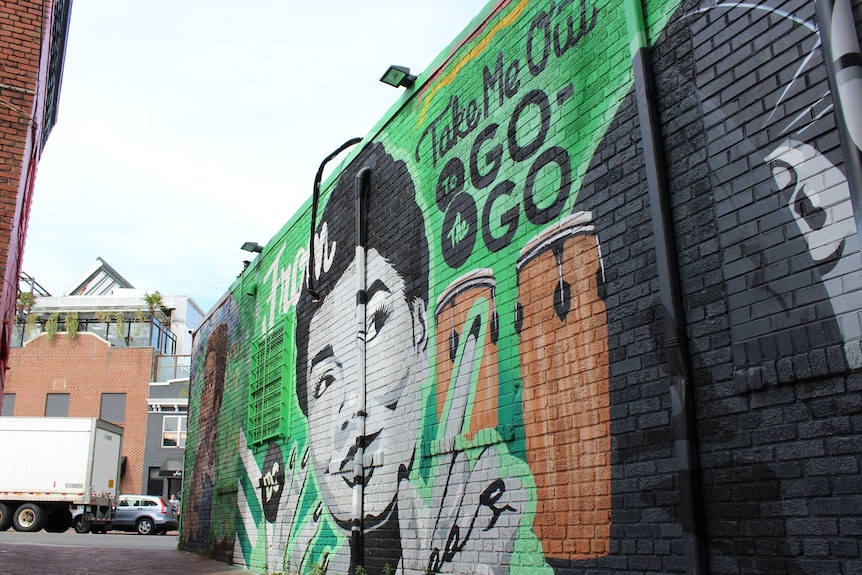 A bright mural with a woman's face and drums