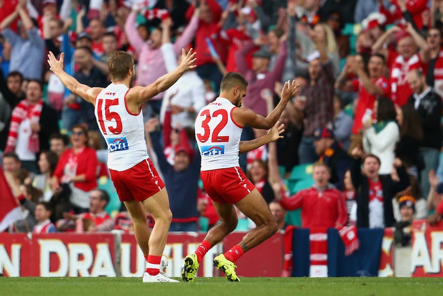 Lewis Jetta celebrates a goal in support of team-mate Adam Goodes