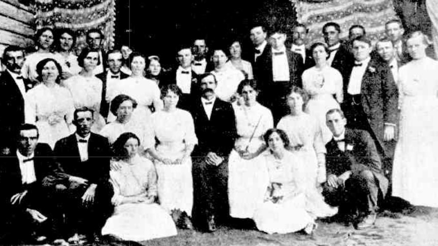 A black and white image of an adult choir, dressed formally, in 1913.