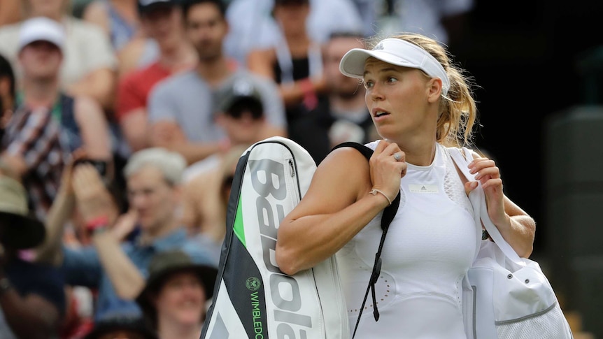 Caroline Wozniacki leaves the court after being defeated by Ekaterina Makarova at Wimbledon.