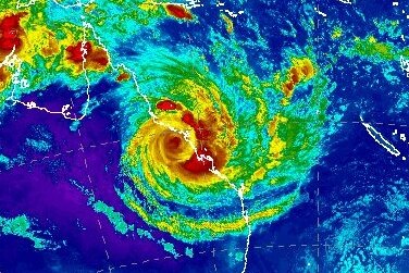 A false-colour satellite image shows the eye of Cyclone Debbie over mainland Australia at 9:30pm AEST.