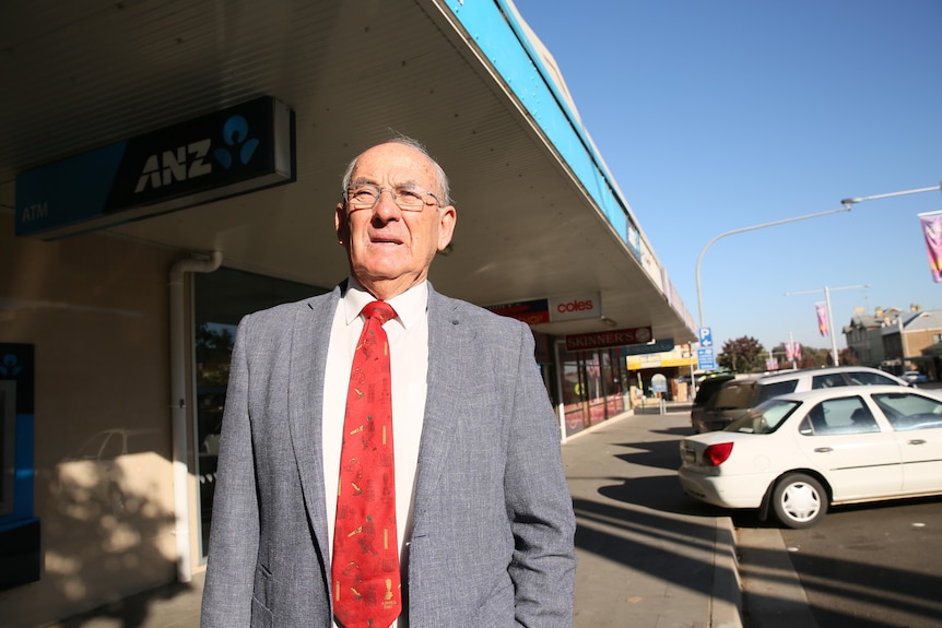 A man stands in the main street of an Australian regional town