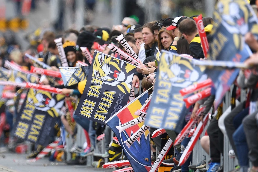Fans line Wellington Parade during the AFL grand final parade in Melbourne.
