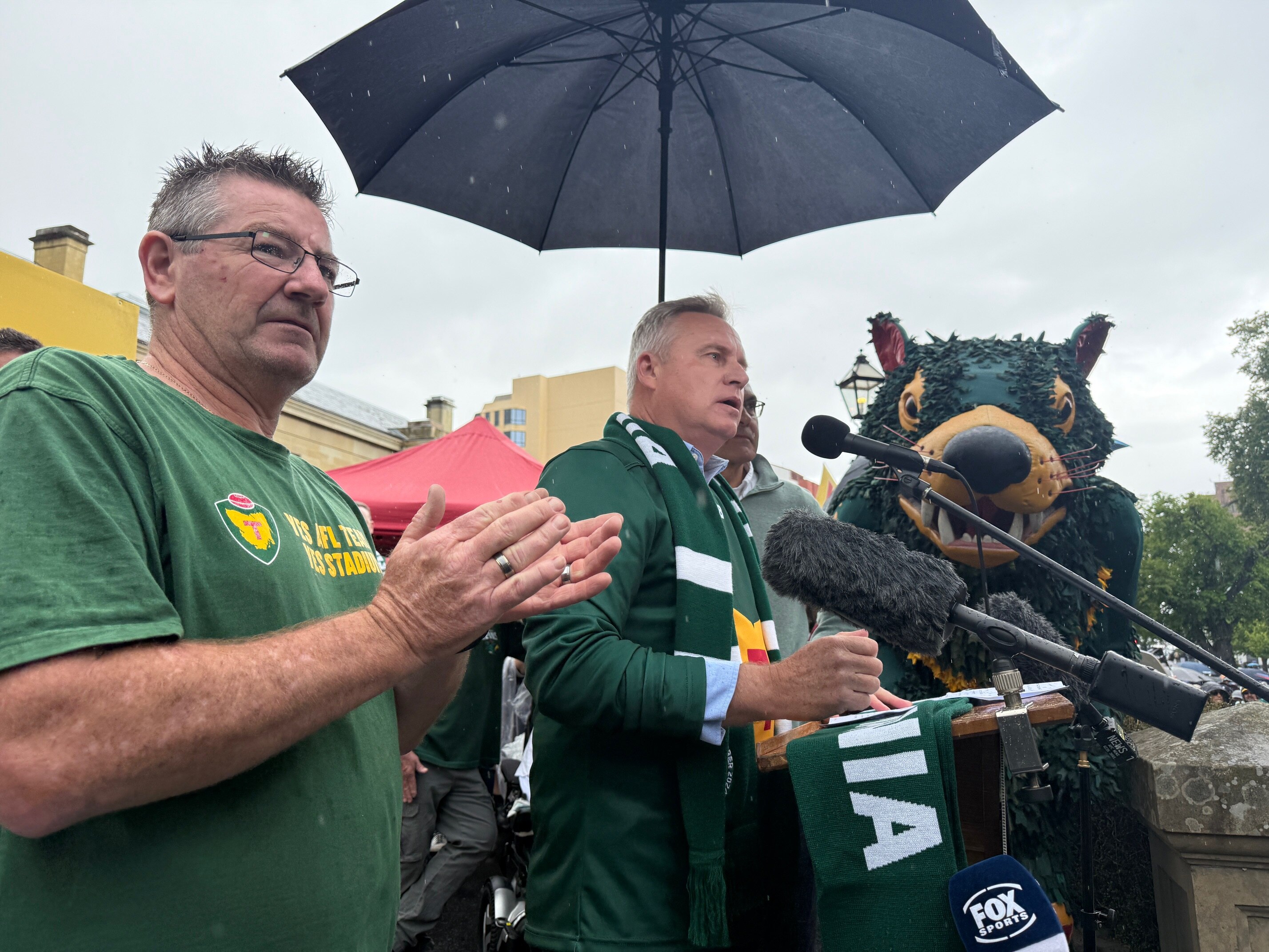Un hombre se encuentra bajo un paraguas.