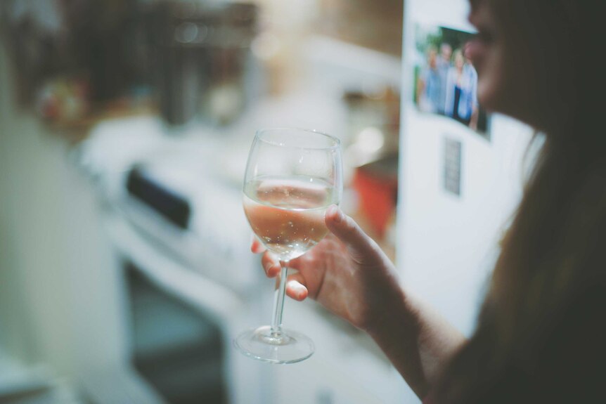 Woman holds a wine glass full of water